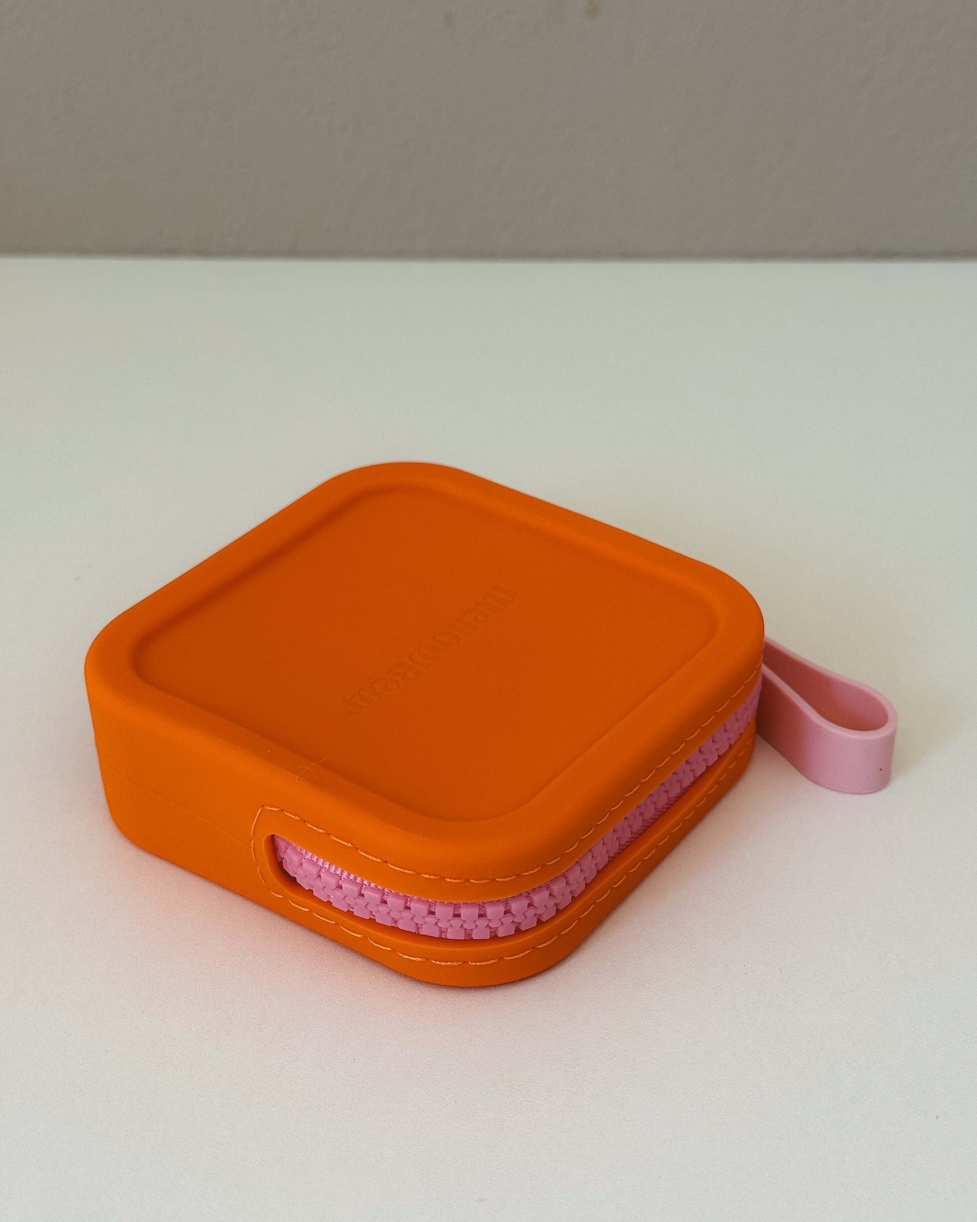 mellowbear【Washable Treats holder】 in vibrant orange silicone with pink zipper, perfect for walks and café time.